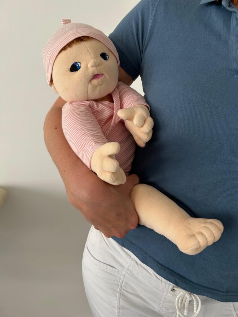 Tragehaltung im Hüftsitz ab dem 6. Monat – fördernde und alltagsnahe Position für Babys, demonstriert in der Kinderphysiotherapie Ritterburg